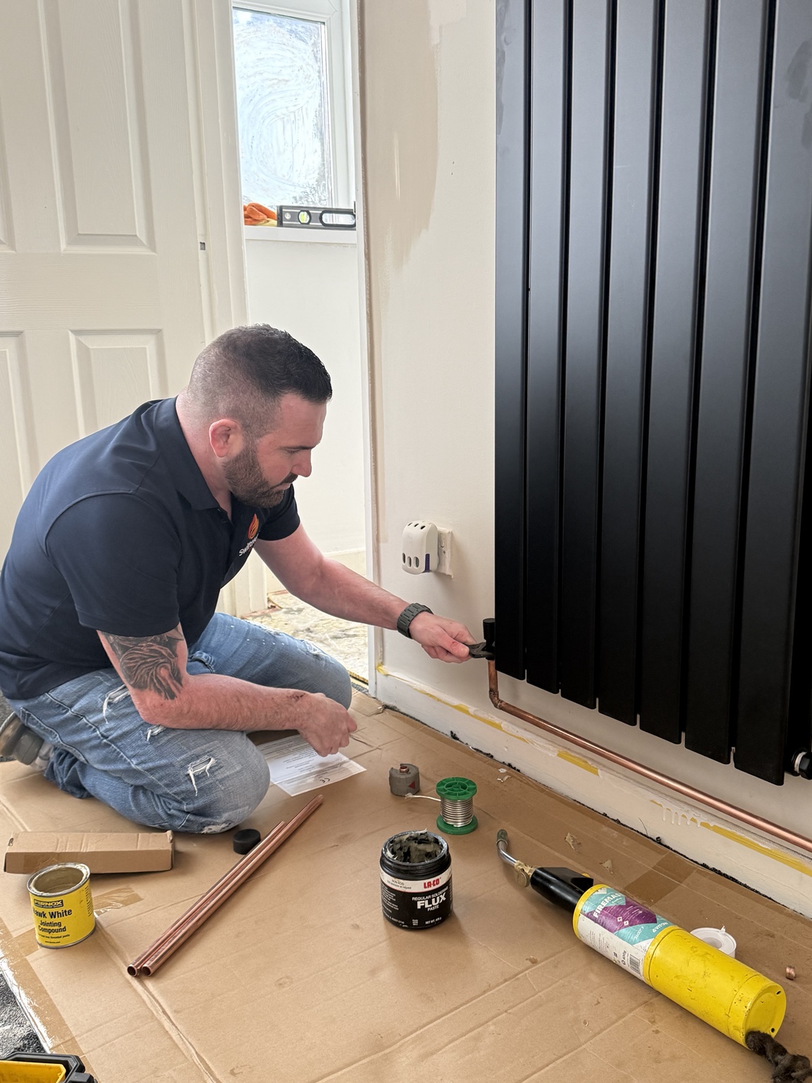 SwiftHeat engineer installing a premium radiator in a real home